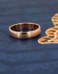 Rose gold wedding ring with a minimalist matte finish and polished details. Handmade by Bena Jewelry, showcased on a dark background for contrast.