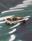 Curved rose gold stacking ring with lab-grown diamonds, highlighted on a deep-toned backdrop. Handcrafted in Montreal by Bena Jewelry.