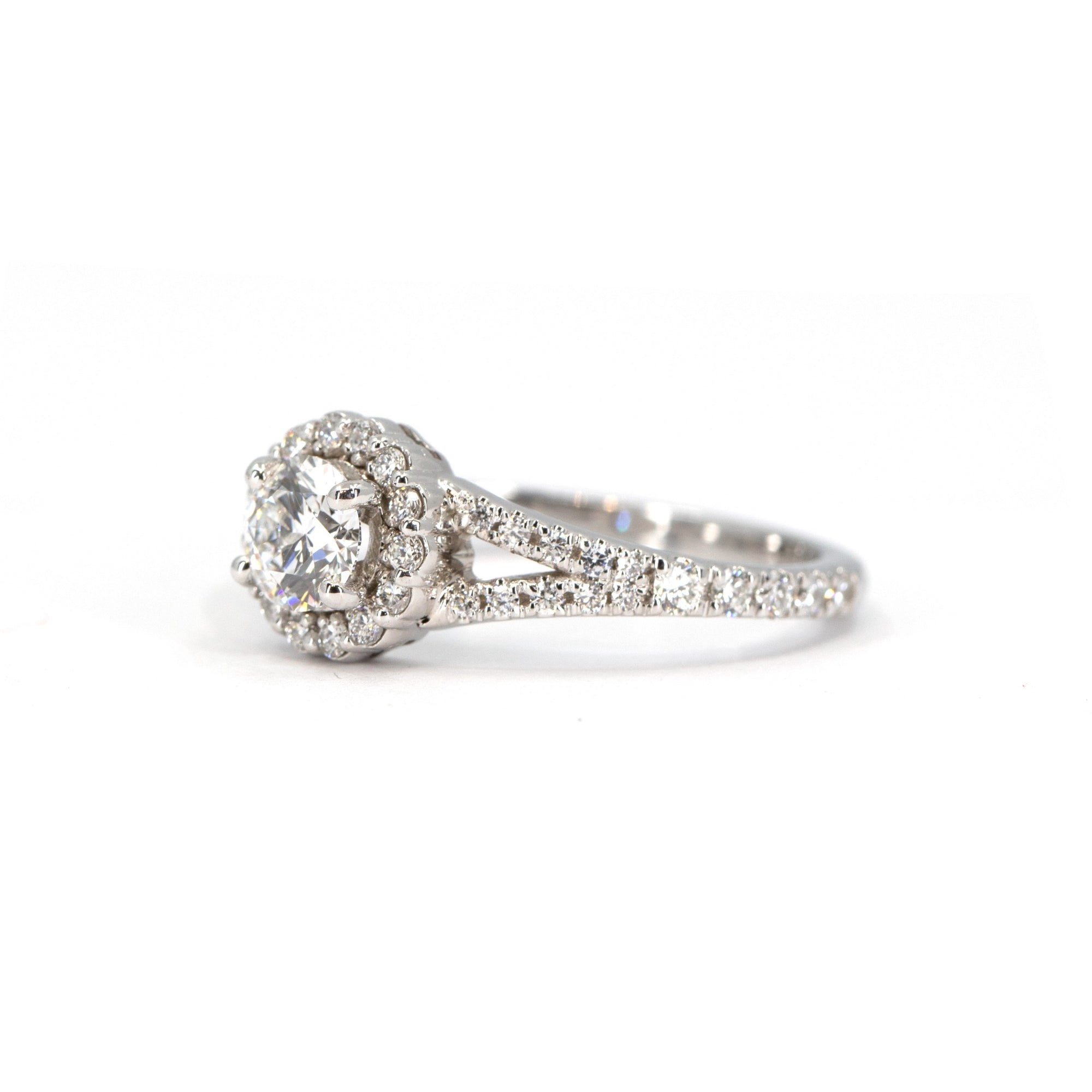 Side view of a white gold engagement ring with a lab-grown diamond halo and accent diamonds on the open band. Elegant and sustainable, crafted in Montreal by Bena Jewelry.