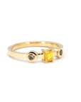 Front-facing image of a contemporary yellow gold ring with a vibrant yellow emerald-cut diamond and two brown accent diamonds, captured on a white backdrop.
