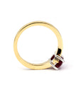 Side profile view on a white background: Elegant yellow gold engagement ring with a natural oval ruby center stone and pavé-set diamonds, handcrafted by Bena Jewelry in Montreal.