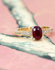 Angled view on a white background: Yellow gold and natural ruby ring with a diamond pavé band, a bridal jewelry piece by Canadian designer Bena Jewelry.