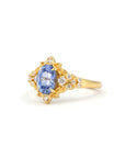 Top-down view of sapphire and gold ring – A dreamlike, custom-made engagement ring with a floral design and a luminous sapphire centerpiece.