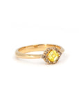 Minimalist product shot of a yellow Asscher diamond ring surrounded by brown diamonds, made by Bena Jewelry in Montreal, shown on a neutral white backdrop.