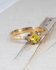 Yellow Asscher-cut diamond ring by Bena Jewelry pops against a vibrant colored background, showcasing its unique contrast and handcrafted 14k gold setting, made in Montreal.