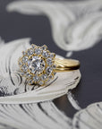 Diamond halo ring in 14k yellow gold on black surface, crafted by Canadian fine jewelry designer Bena Jewelry – engagement or statement piece