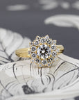 Soleil ring in yellow gold with white diamonds, glowing against dark background – bold floral halo design by Bena Jewelry, Montreal