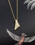 Edgy Pyramidal Pendant in yellow gold with diamond paving, shown against a striking black background, emphasizing its modern, geometric design by Bena Jewelry.