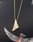 Close-up of the Edgy Pyramidal Pendant in yellow gold, featuring intricate diamond paving and bold triangular lines, set against a sleek black backdrop by Bena Jewelry.