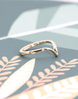 Custom Yellow Gold Wedding Band stacked with an engagement ring, made in Canada – A tailored V-shaped design that complements various engagement ring styles.