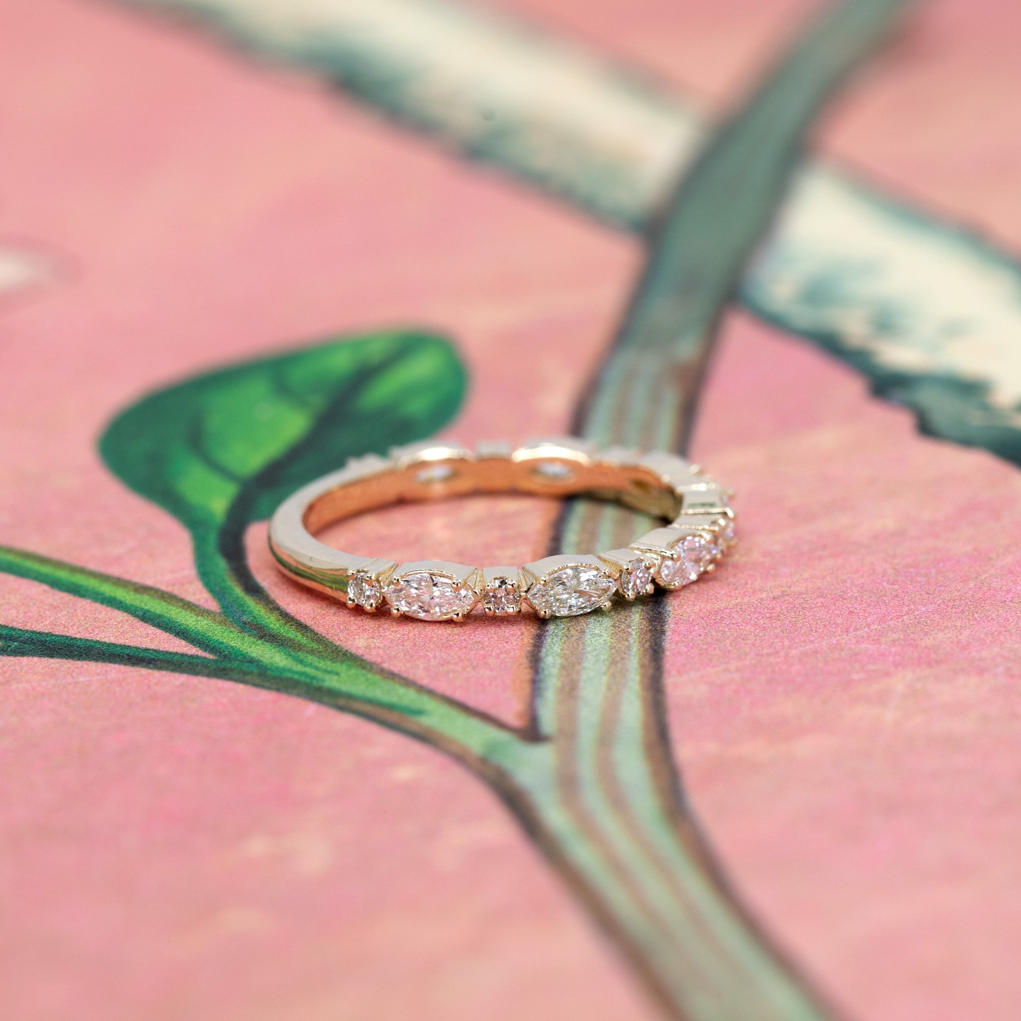 Close-up of the yellow gold bridal ring, featuring alternating marquise and round diamonds.