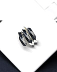 Embrace Ring in White Gold on soft-toned background – The sleek geometric structure of this unisex ring contrasts elegantly with the neutral backdrop.