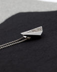 Close-up of a geometric diamond pendant in white gold, showcasing its sculptural and contemporary appeal. A sophisticated statement piece by Bena Jewelry, presented on a dark background.