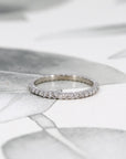 White gold eternity band styled to complement a diamond engagement ring. Designed by Bena Jewelry, this custom-made piece pairs classic elegance with a modern touch, handcrafted in Montreal.