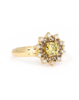 Close-up of the Soleil yellow diamond ring, featuring a central yellow diamond surrounded by brown and white diamonds, displayed against a white background by Bena Jewelry.