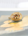 Minimalist yellow gold ring with an oval golden sapphire in a bezel setting and halo design. Contemporary and unique fine jewelry by Bena Jewelry, made in Montreal.