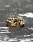 Open moon-inspired diamond ring in yellow gold, highlighted against a dark background. Designed by Bena Jewelry in Montreal, Canada.