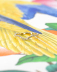 Timeless yellow gold curved wedding band with diamonds, crafted to pair with an engagement ring. Photographed on a bold background, designed by Bena Jewelry.