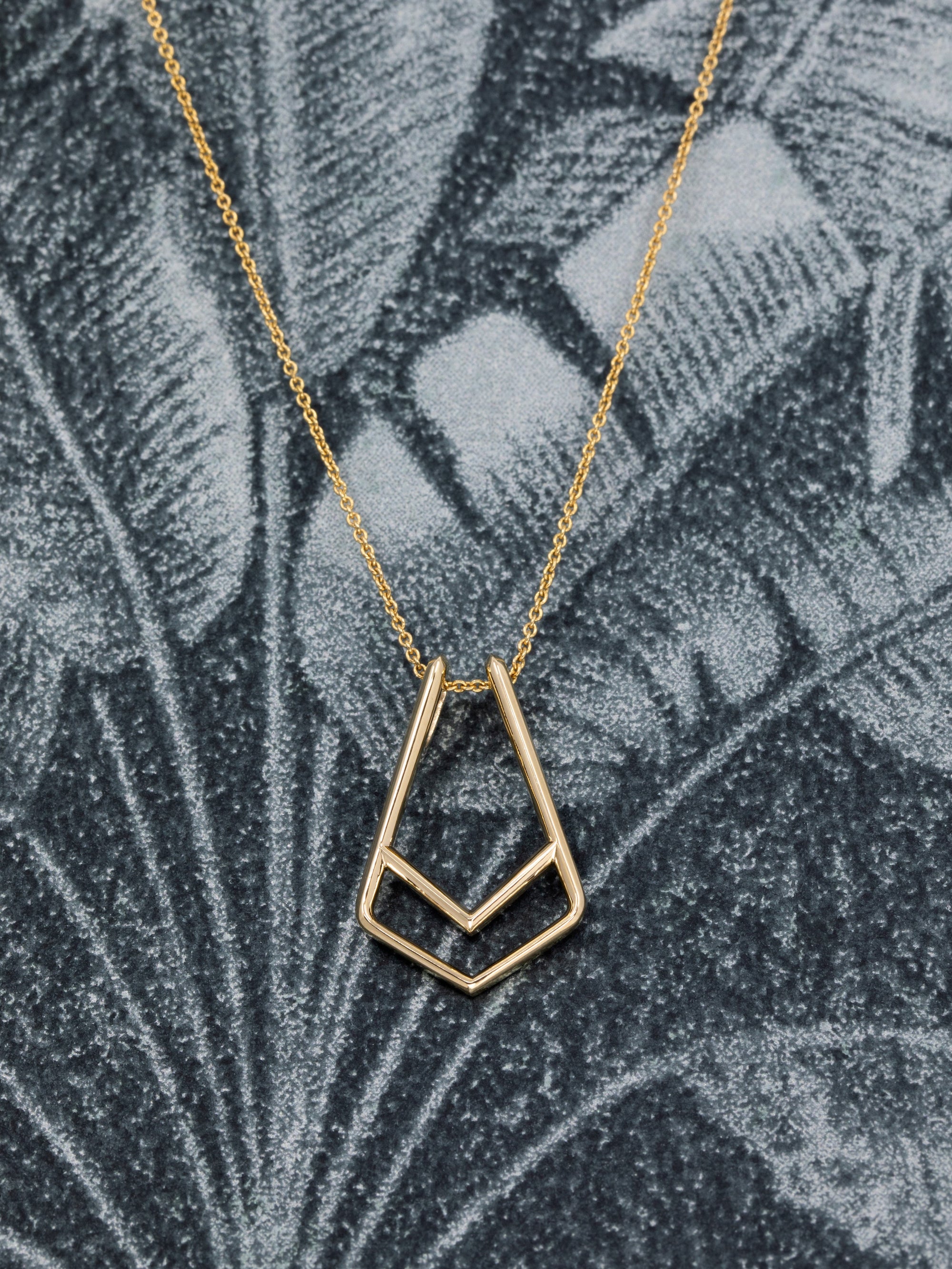 Handcrafted gold pendant with a unique curved design – A modern and edgy take on fine jewelry, featuring a seamless ring slot for effortless wear.