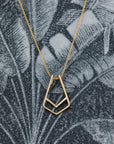Handcrafted gold pendant with a unique curved design – A modern and edgy take on fine jewelry, featuring a seamless ring slot for effortless wear.