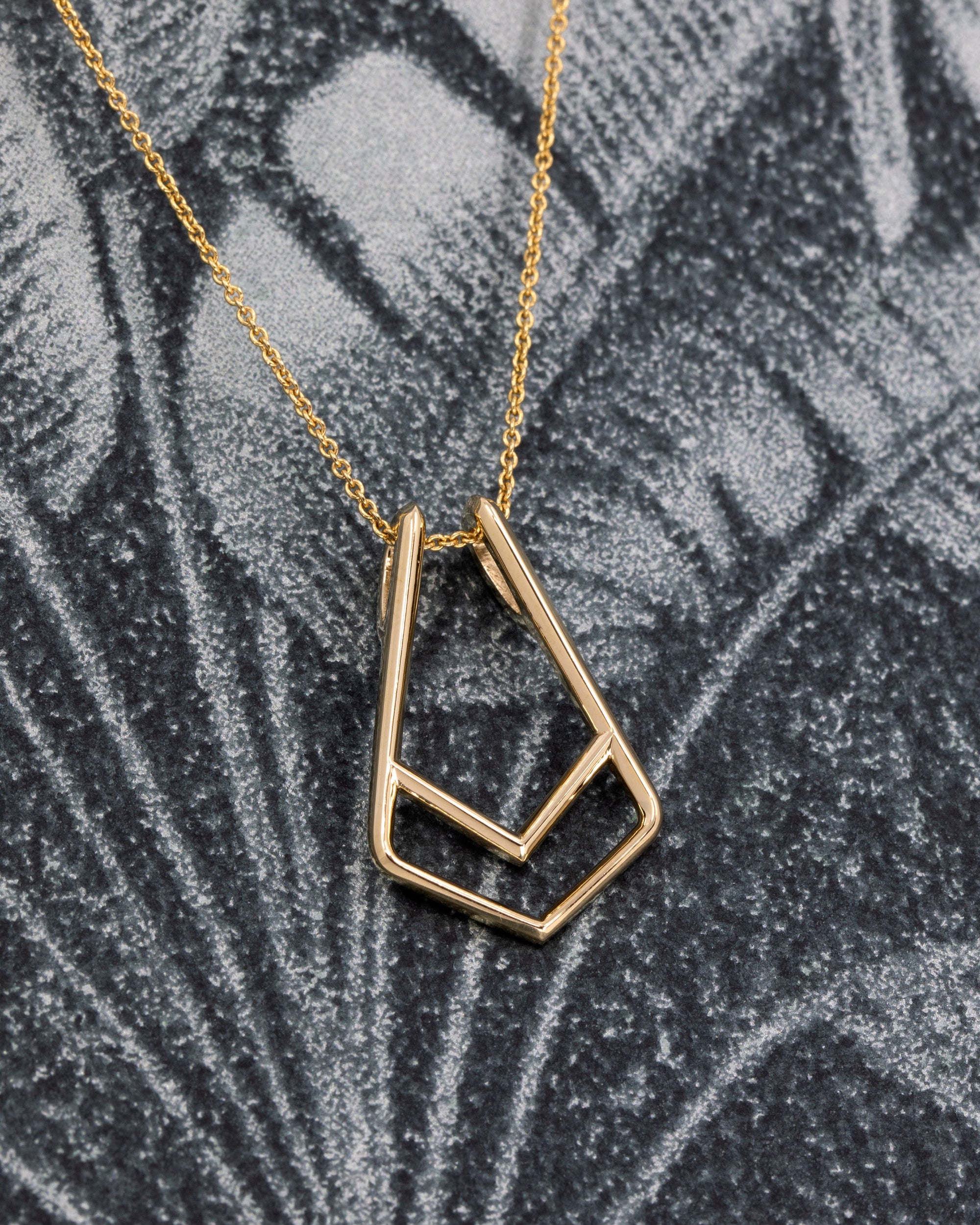 Close-up of Ring Holder Pendant in Yellow Gold – A contemporary fine jewelry piece with a minimalist and functional design.