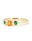 Yellow gold ring with a baguette-cut orange sapphire and two green garnet side stones, handcrafted by Bena Jewelry in Montreal, Canada.