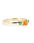 Custom designer ring in yellow gold featuring a vibrant orange sapphire and green garnets, made by Bena Jewelry in Montreal.