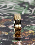 Trois Vagues yellow gold men's wedding band, displayed with a contemporary colored backdrop, emphasizing the sleek lines. Made in by Bena Jewelry Montreal.
