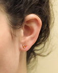 Girl wearing trillion orange sapphire yellow gold stud earrings bena jewelry