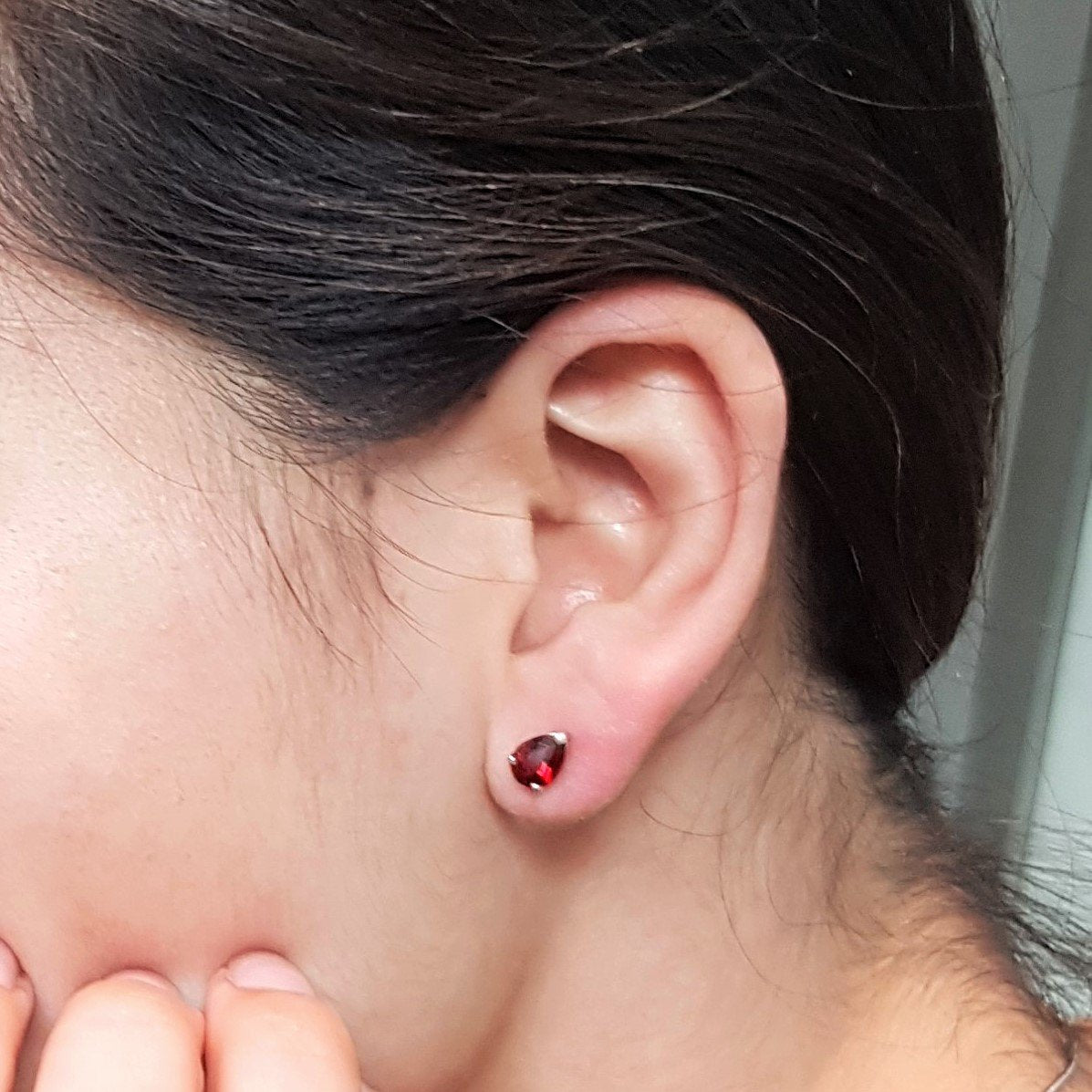 Girl wearing pear cut pyrope garnet stud earrings bena jewelry montreal pear shape red garnet gemstone montreal little italy jeweler red gemstone earrings