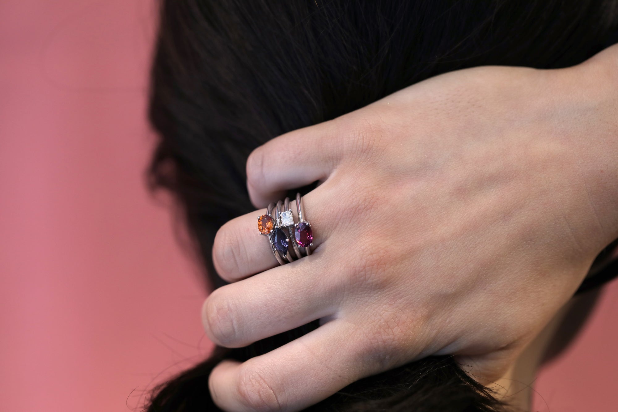 Girl wearing stackable color gemstone rings montreal made garnet gemstone engagement ring purple spinel bridal ring handmade in montreal small minimalist squre diamond little italy montreal jeweler dainty orange oval natural zircon gold ring montreal handmade in canada