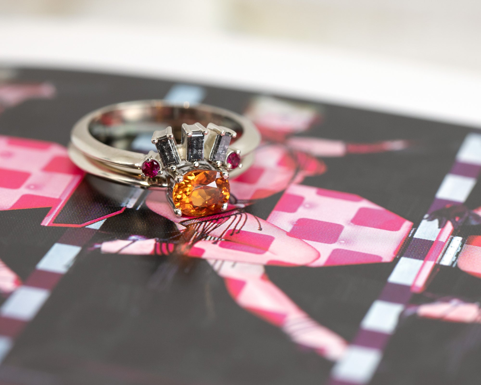 white gold garnet engagement ring made and salt and pepper ring and ruby on multicolor background