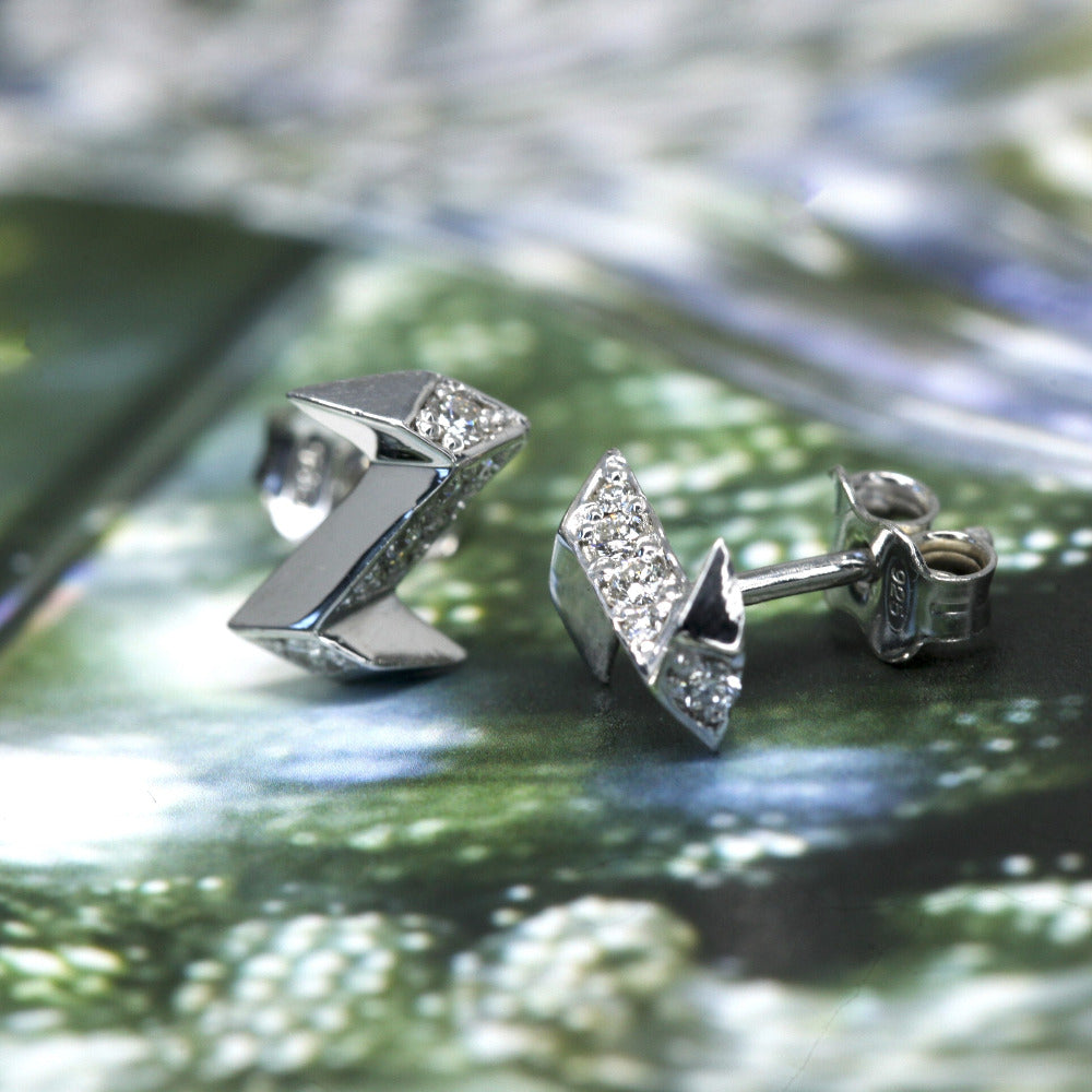 Natural light silver stud earrings thunder shape with round diamond Bena Jewelry Montreal On Green Background Side View