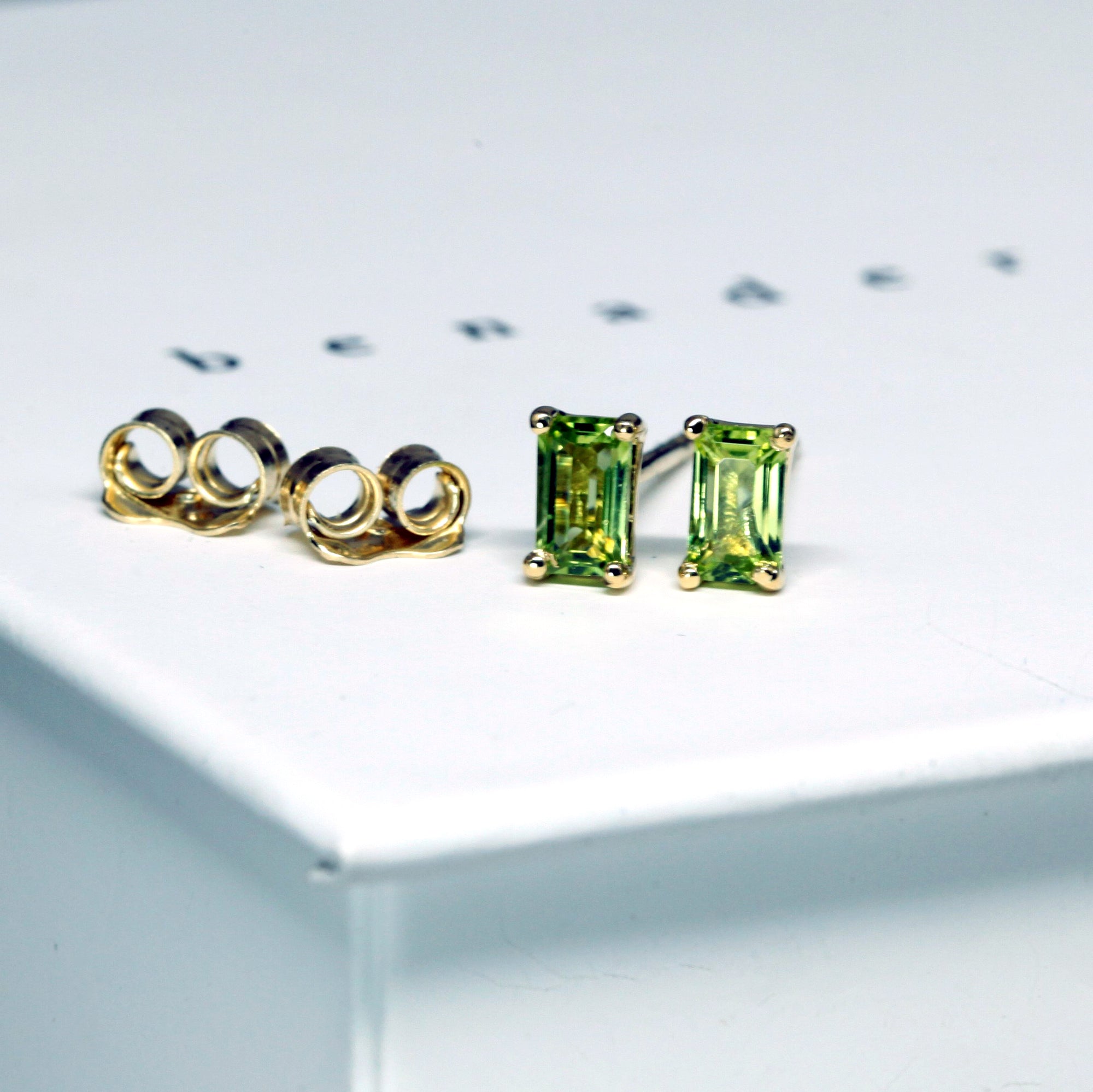 front view of peridot gemstone yellow gold stud earrings bena jewelry montreal made jewelry custom made color gems jewelry minimalist earrings bridal color gemstone jewelry natural vivid green gemstone jewelry