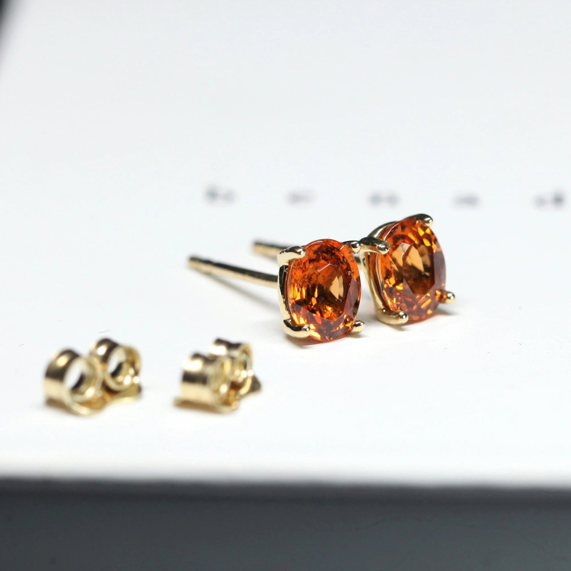 side view of garnet earrings oval shape spessartite orange gemstone stud earrings natural orange color yellow gold stud earrings oval shape vivid orange gemstone stud earrings custom made color gemstone bridal jewelry montreal bena jewelry designer