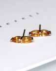 front view of edgy pear shape saphirre earrings stud color gemstone custom made jewelry montreal handmade in canada simple shape pear gemstone vivid orange natural color jewelry specialist montreal