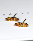 Front view of bena jewelry pear shape orange saphirre orange vivid natural gemstone custom made earrings montreal made in canada fien edgy jewelry montreal