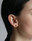 girl wearing orange garnet gemstone stud earrings spessartite garnet oval shape yellow gold fine jewelry montreal jewelry designer small color gemstone simple minimalist jewelry designer montreal color gemstone bridal jewelry specialist