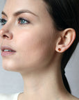 girl wearing a spessartite garnet gemstone stud earrings bena jewelry montreal made in canada oval shape garnet yellow gold stud earrings color gems bridal jewelry custom made in montreal fine jewelry ethical jewelry studio little italy montreal fine jewelry designer