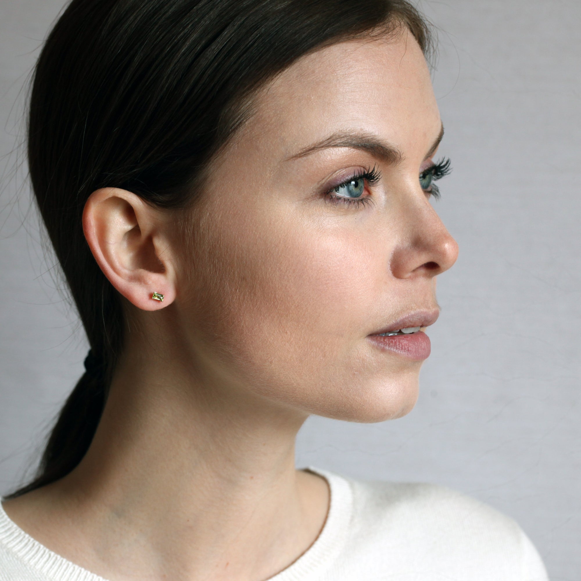 top view of a girl wearing bena jewelry gemstone studs earrings montreal color gemstone jewelry specialist handmade jewelry small gems jewelry green gemstone small gold earrings bena jewelry edgy gemstone jewelry
