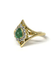 Side view emphasizing the ring's yellow gold band and intricate halo design around the emerald. A bespoke creation crafted by Bena Jewelry in Montreal, Canada.