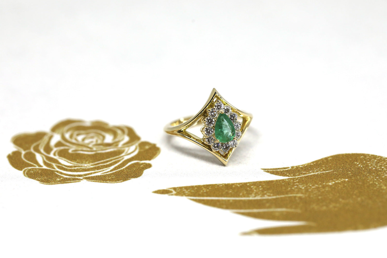 The Adorn Pear Shape Emerald & Halo Ring, showcasing its vibrant emerald and refined yellow gold design. Made in Montreal, Canada, by Bena Jewelry, a bespoke piece.