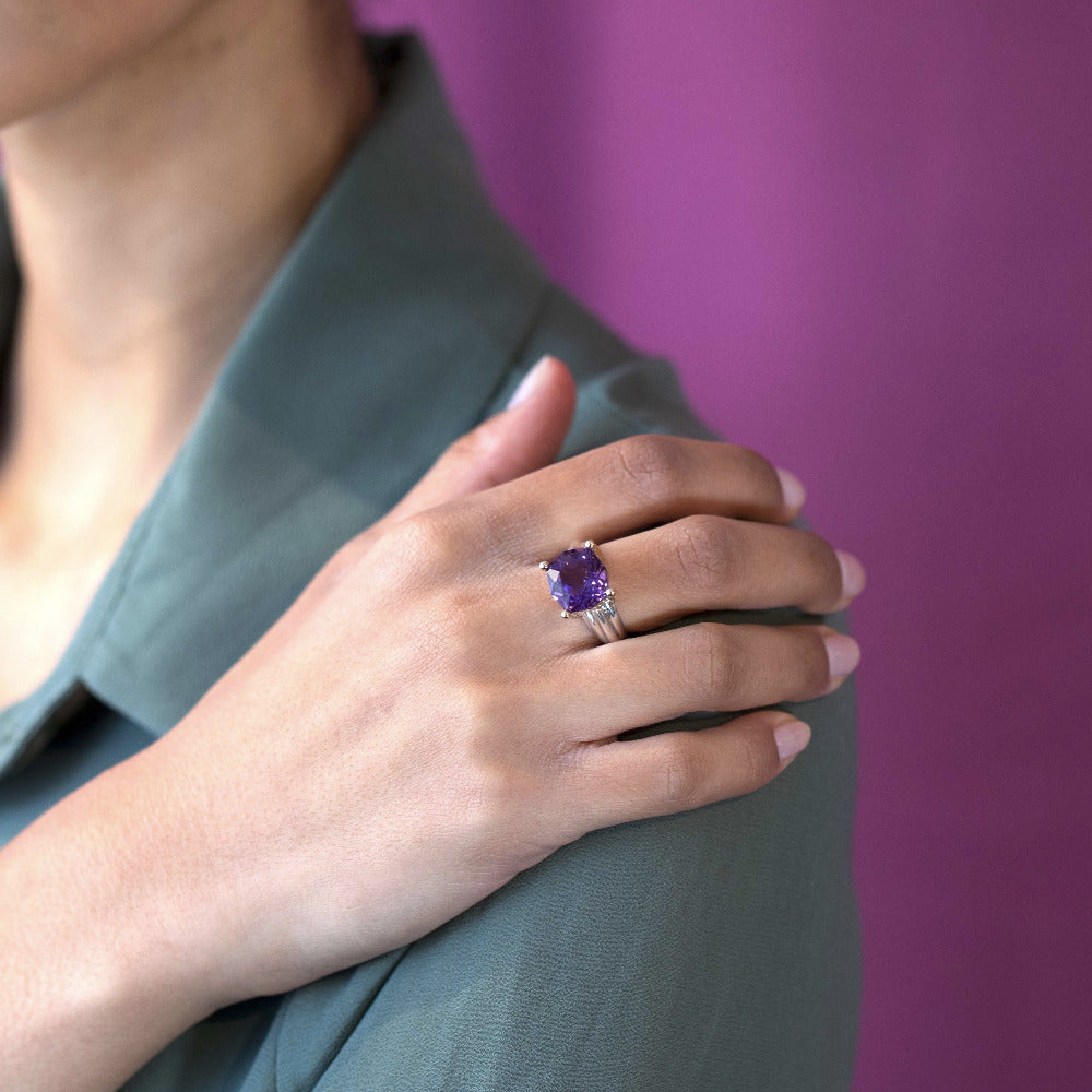 Close-up of the ring worn (lifestyle): Focus on the amethyst’s brilliance and the contrasting silver and gold elements on the hand.