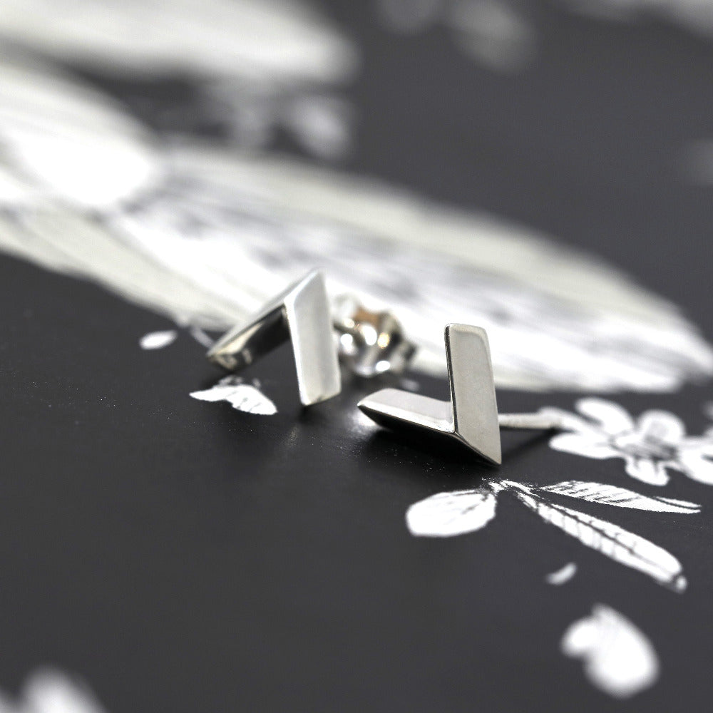 Arrow Stud Earrings on white background – Minimalist and edgy gold stud earrings in a sleek arrow shape, crafted by Bena Jewelry in Montreal.