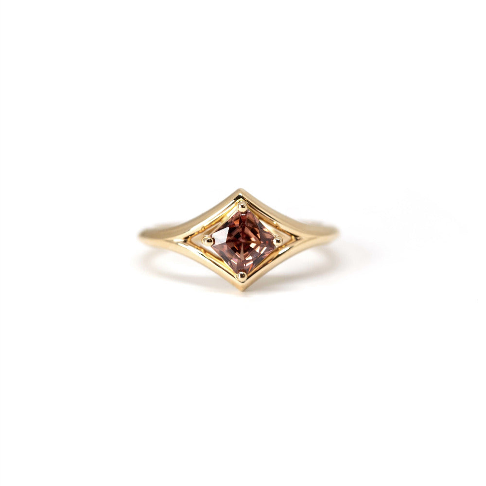 Front view of close-up: Focuses on the gemstone’s vibrant peach tones and the smooth finish of the yellow gold band. Designed by Bena Jewelry, an independent jeweler in Montreal, Canada.