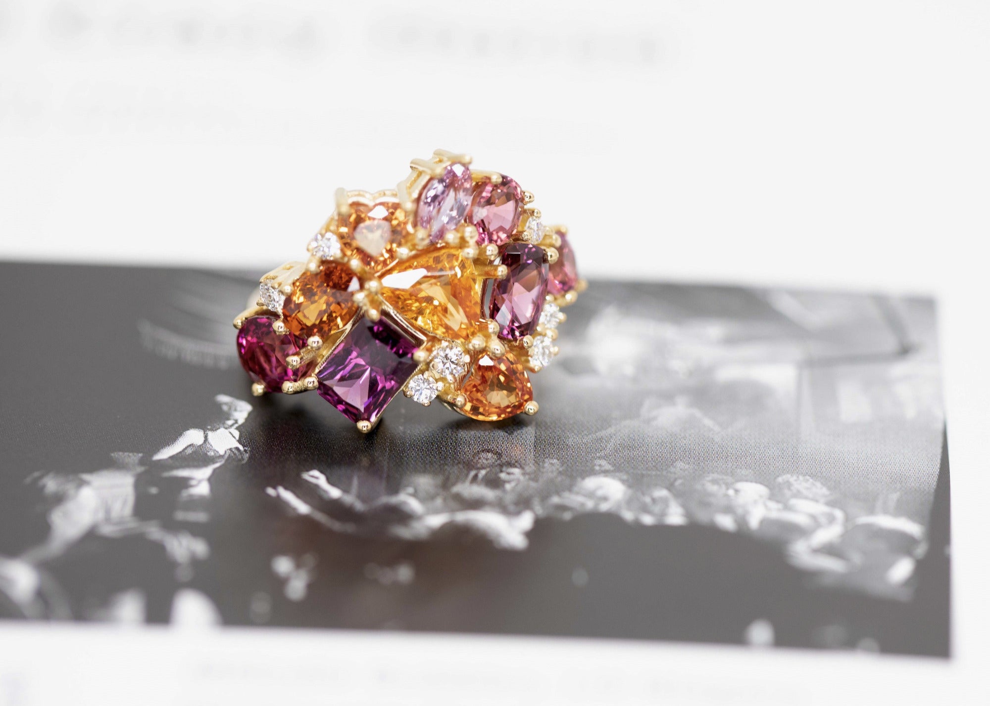 Top-down view: Displays the bold arrangement of gemstones and the harmonious integration with the yellow gold band. Designed by Bena Jewelry in Montreal, Canada.