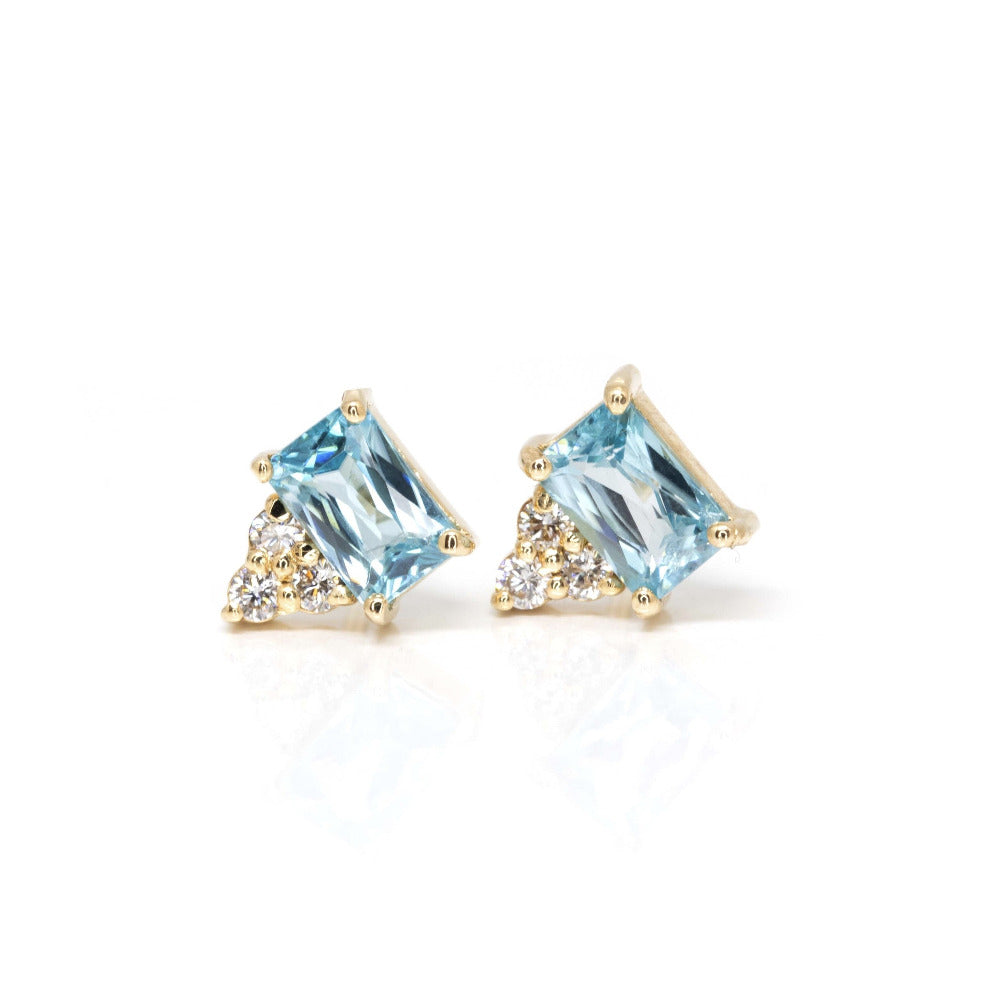 Yellow gold earrings featuring sky-blue emerald-cut zircons and three extra-brilliant white diamonds, crafted by Bena Jewelry in Montreal.