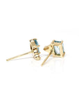 Close-up of natural zircons in a vibrant sky-blue hue paired with sparkling diamonds, set in yellow gold prongs.