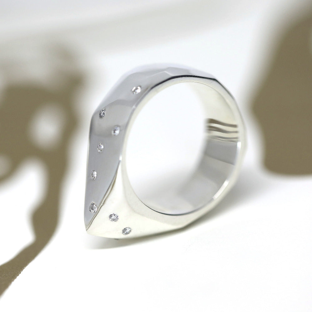 A contemporary unisex ring in luminous white gold with organic movement and diamond pavé. Designed and handcrafted by Montreal-based Bena Jewelry.