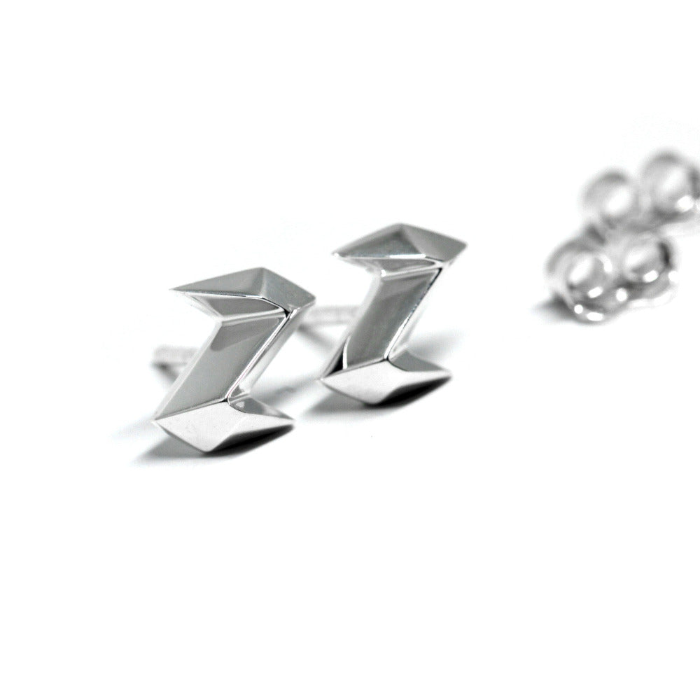 Electric Edgy Studs worn on ear, close-up – A sleek, minimalist gold stud earring with a sharp, electric-inspired silhouette. Designed by Bena Jewelry in Montreal.